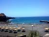 Blick auf den Strand mit Liegestühle und Sonnenschirme in Callao Salvaje an der Südküste von Teneriffa